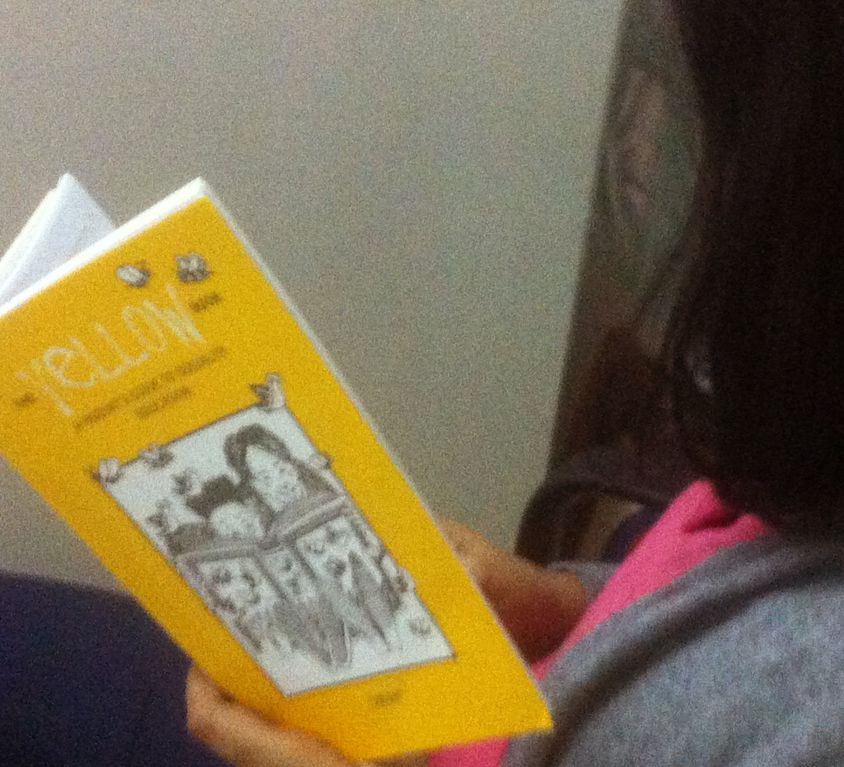 A person with short dark hair reads TARSHI's The Yellow Book