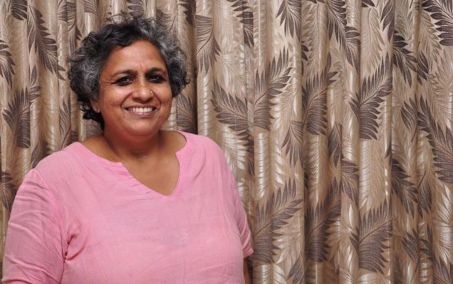 A photo of Anjali Gopalan, who has short black and gray hair and dark eyes. Anjali is smiling, wearing a light pink dupatta. Source: Naz Foundation