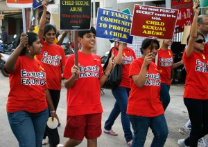 A photo of a few children dressed in matching red shirts that read 'enough is enough' and holding up placards with various slogans