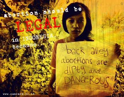 A woman holding up a placard which talking about why abortion should be legal in Indonesia