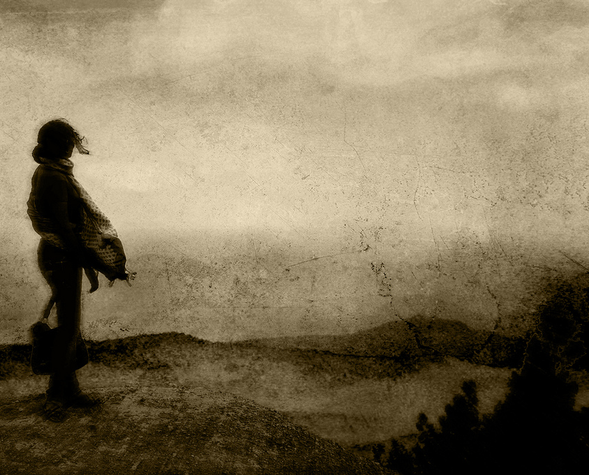 Silhouette of a woman walking on an abandoned road