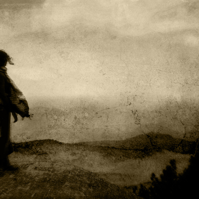 Silhouette of a woman walking on an abandoned road