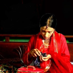 A young girl dressed in red looking downwards