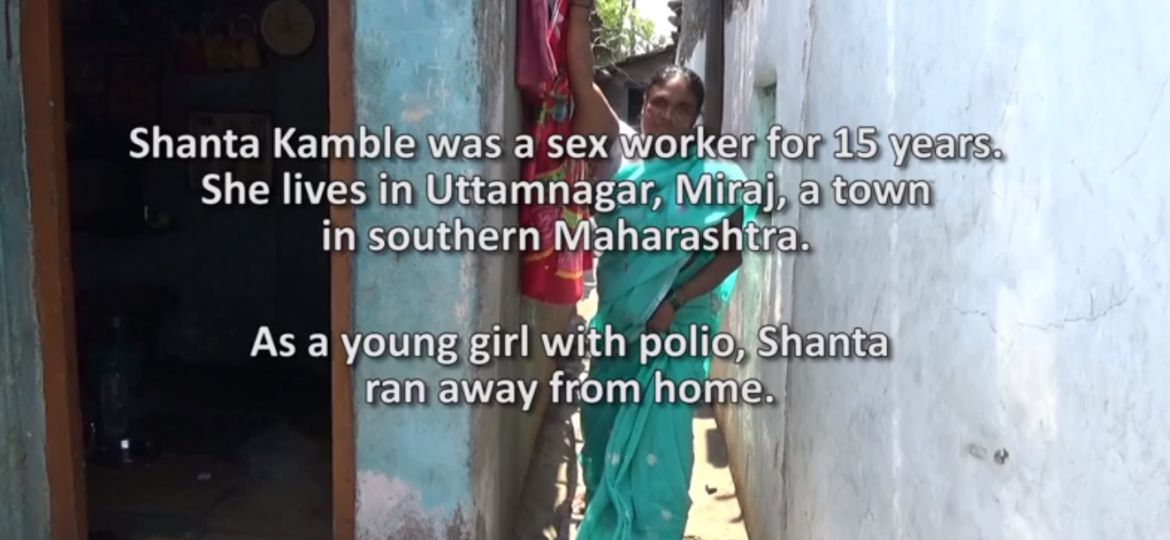 Photo of a woman in a light blue salary standing leaning against a wall in what looks like arun-down neighbourhood. The text over the image reads: "Shanta Kamble was a sex worker for 15 years. She lives in Uttamnagar, Miraj, a town in southern Maharashtra. As a young girl with polio, Shanta ran away from home."