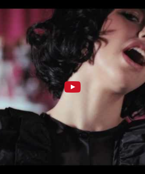 a screengrab from kimbra's music video, "settle down", which shows singer kimbra throwing her head back and singing. she is far and has short dark hair