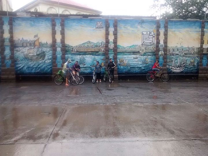 Picture of a street with a few kids milling about on bicycles