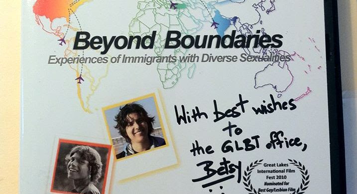 A white board with a couple of polaroid pictures and the text "Beyond Boundaries: Experiences of Immigrants with Diverse Sexualities". The words "With love to the GLBT office, Betsy" are written in permanent marker