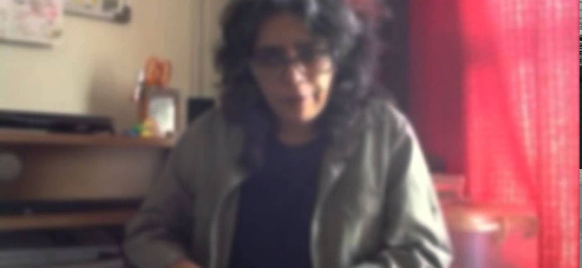 Photo of TARSHI's founder Radhika Chandiramani. She has curly shoulder length hair and is wearing a grey sweater over a maroon top