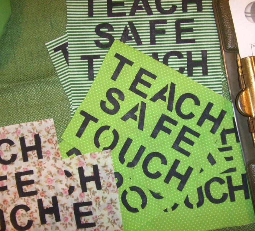 A series of pink and green placards that read 'Teach Safe Touch'