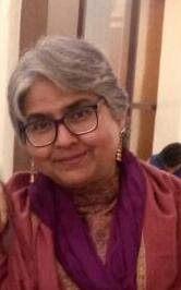 Headshot of psychologist Sadhna Vohra, she has white hair and dark glasses and is wearing an orange dupatta around her neck