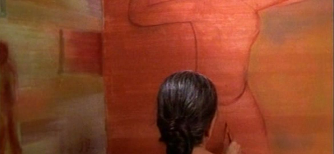 A woman in a black saree and white blouse faces a red wall, so that only her back is visible