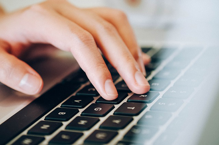 Stock image of a hand typing a keyboard.