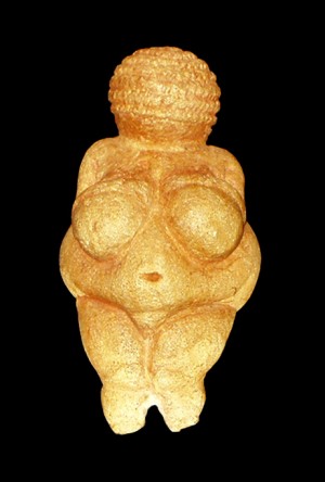 Venus figurine in golden colour in a pitch dark black background.