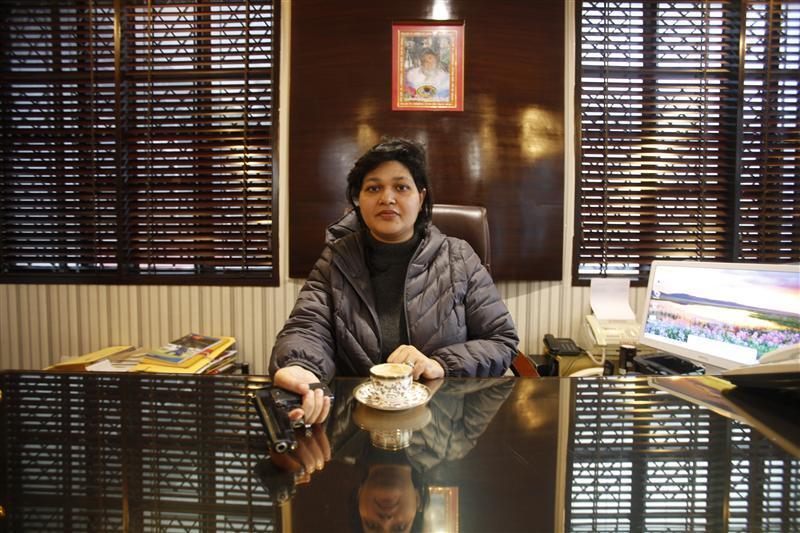 Nalini Bharatwaj, 37, chairman of a management institute, holds a gun while posing in her office in New Delhi January 16, 2013.