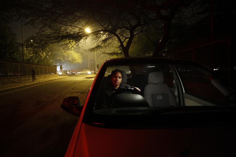 Chandani, 22, who works as a cab driver, sits inside her car on a street in New Delhi
