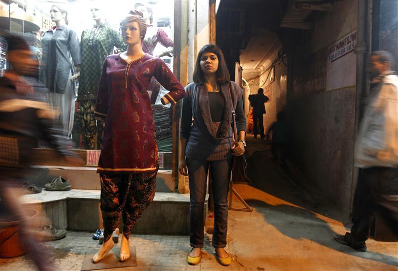Richa Singh, 24, who works for an online travel portal, poses next to a mannequin at a market in New Delhi