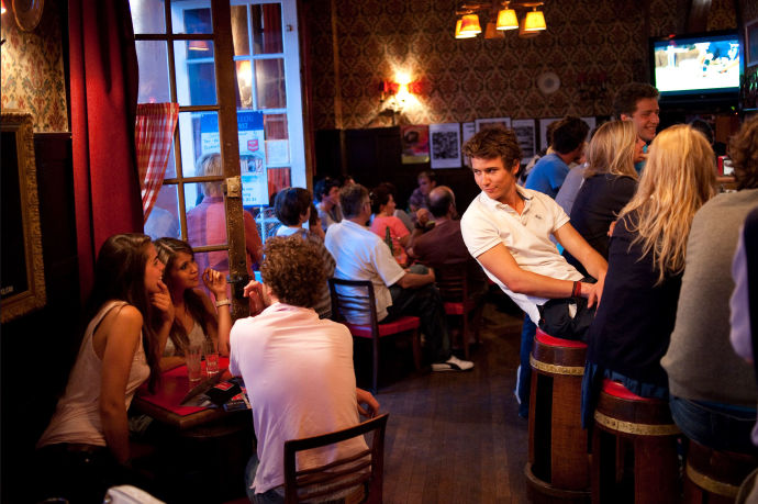 A man eyeing two girls sitting nearby in a bar.