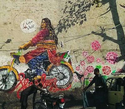Wall graffiti showing a plus-sized woman dressed in a lehenga on a motorbike