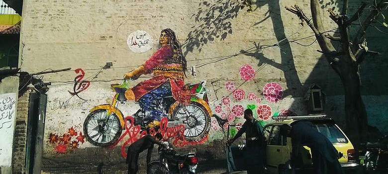 Wall graffiti showing a plus-sized woman dressed in a lehenga on a motorbike