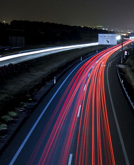 An expressway with red neon lights on the road.