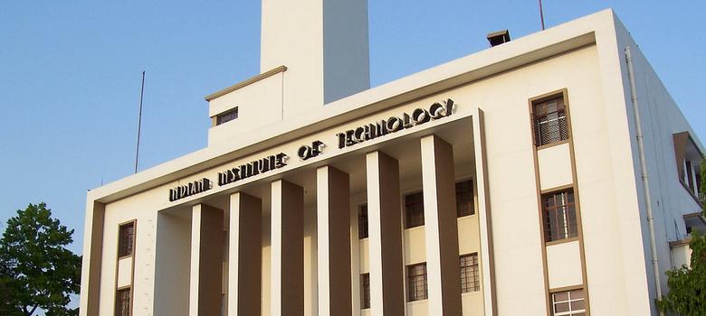 Photo of a front of a light yellow-painted college building. At the top of the building are the words, "Indian Institute of Technology".