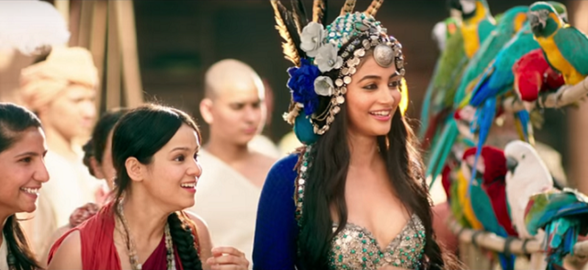 Pooja Hegde in film 'Mohenjo Daro' wearing a big headdres with white and blue roses, and feathers popping out of it.