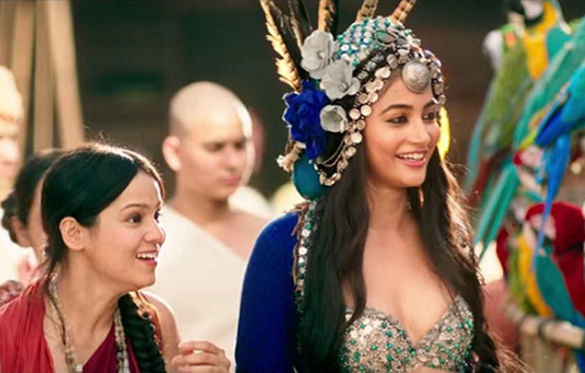 Pooja Hegde in film 'Mohenjo Daro' wearing a big headdres with white and blue roses, and feathers popping out of it.
