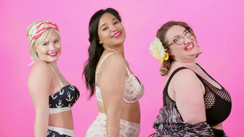 Three women of different sizes who could be called healthy and fat, each wearing a bikini, and smiling proudly at the camera.