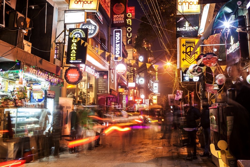 A photograph of a city street. (Haus Khas Village Lane)