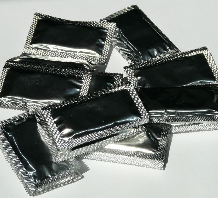 Photo of a strip of small black plastic packets of contraceptives.