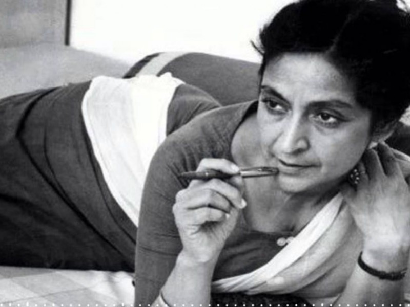 Black-and-white photo of saree-clad writer Amrita Pritam, holding a pen by her cheek thinking something.
