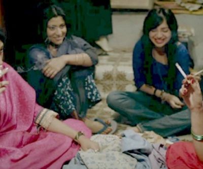 screenshot from the movie Lipstick under my Burkha. four women are sitting together, talking, laughing. two of them hold cigarettes.
