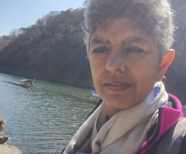 Photo of activist Nandini Rao. She has white hair and is wearing a jacket and scarf.