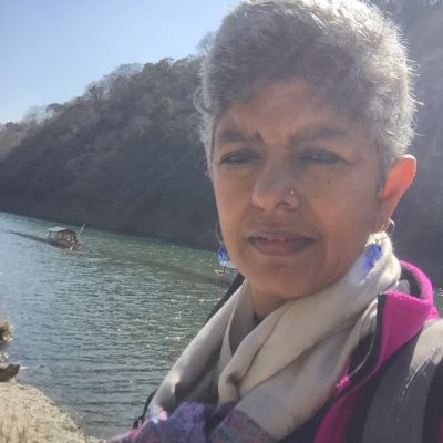 Photo of activist Nandini Rao. She has white hair and is wearing a jacket and scarf.