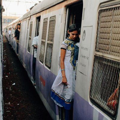 Photo of a woman standing in the entrance of a local train in Mumbai