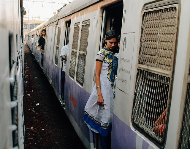 Photo of a woman standing in the entrance of a local train in Mumbai