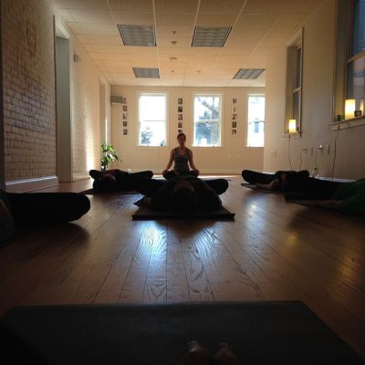 picture of a woman meditating in an empty room with dark brown interiors
