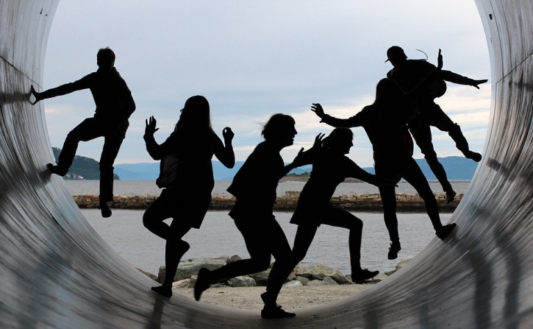 a photo of four silhoutted figures against a blue background