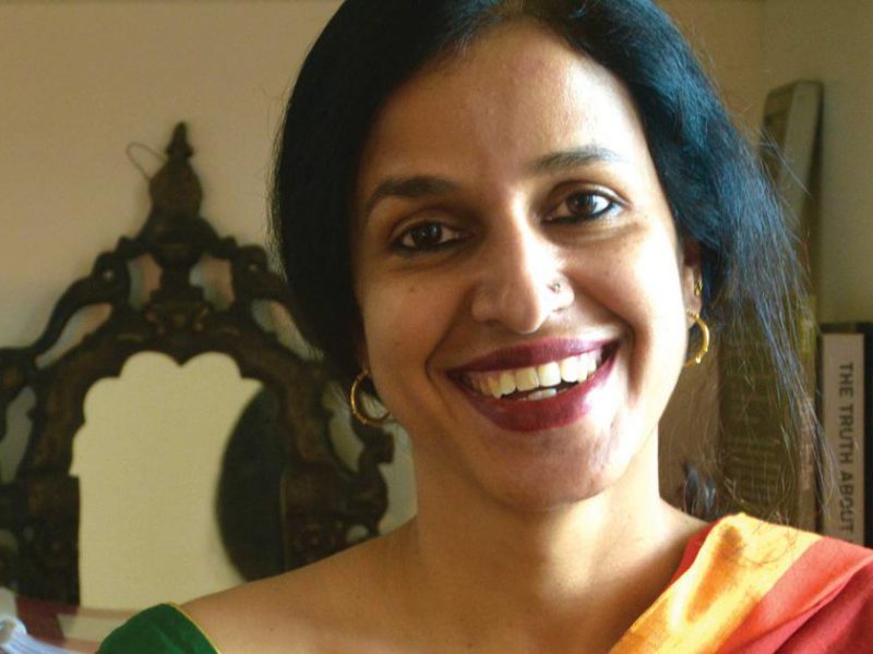 Picture of author Madhavi Menon. She is wearing a yellow saree.