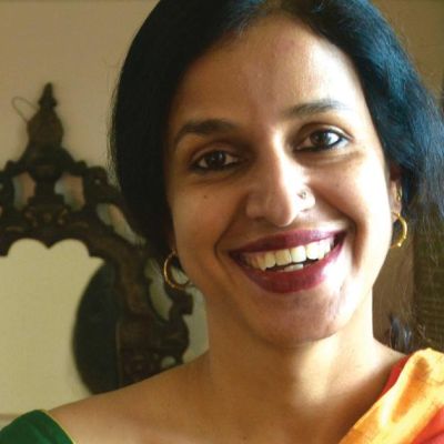 Picture of author Madhavi Menon. She is wearing a yellow saree.