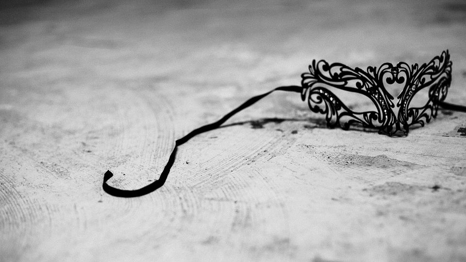 Picture of a black lacy mask with a black string portruding from it