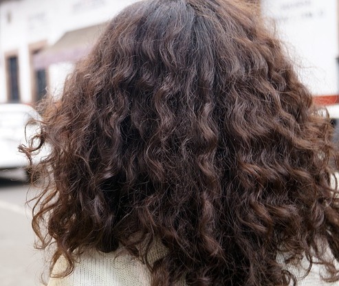 A woman with curly hair faced away from the camera