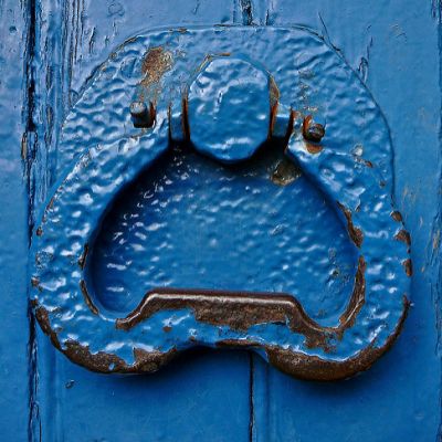 Picture of a wooden door and door knocker, painted bright blue