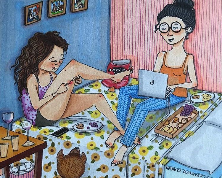 two women sit on a bed in casual nightclothes, one of them concentrating on a laptop and the other inspecting a boil on her leg