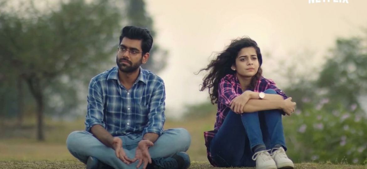 Still from Netflix's 'Little Things' : a man and woman sit beside each other in the grass