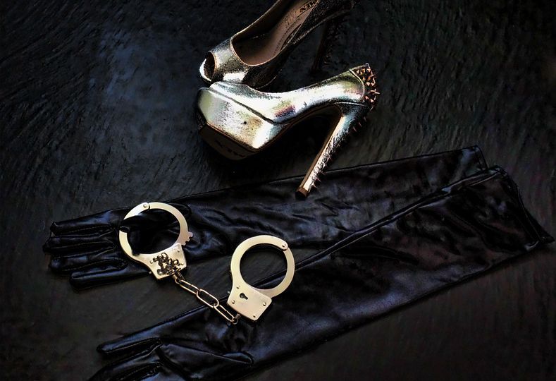Silk black gloves, along with a pair of heels and handcuffs