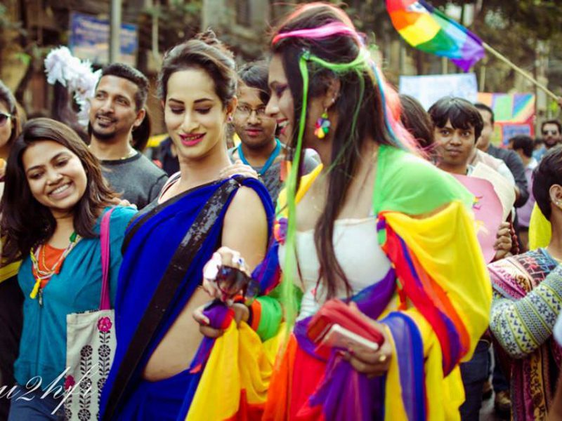 People marching at queer pride, with colourful clothes on