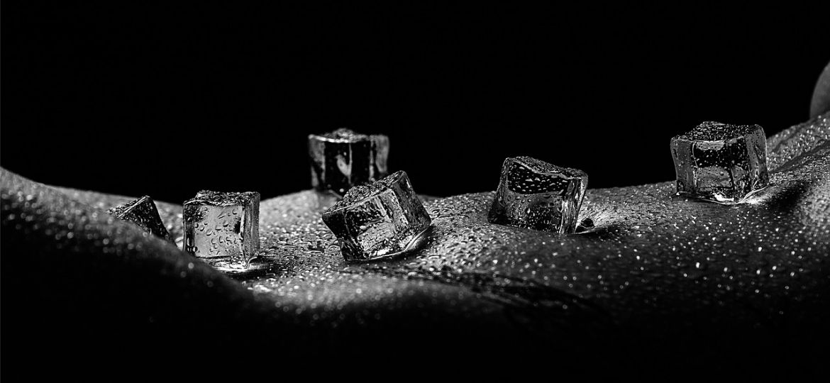 Black and white image of ice cubes on exposed skin