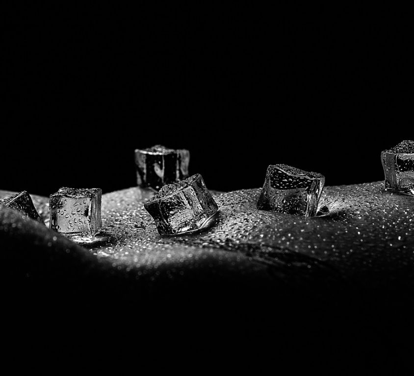 Black and white image of ice cubes on exposed skin