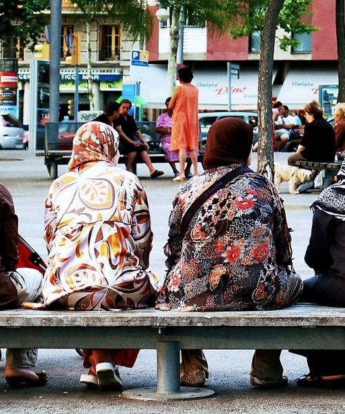 सार्वजनिक स्थान पर एक समूह में बैठी महिलाएँ